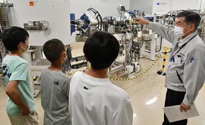 スタッフに説明を受けながら施設見学を行う中学生