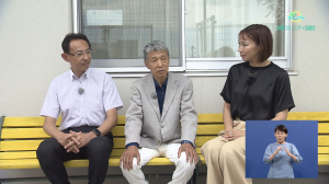 濱田市長と女性リポ―タ―と桃園コミュニテイ協議会北國会長がベンチに座っている様子