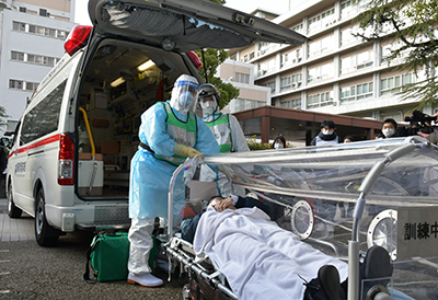 患者を救急車に乗せる消防署員