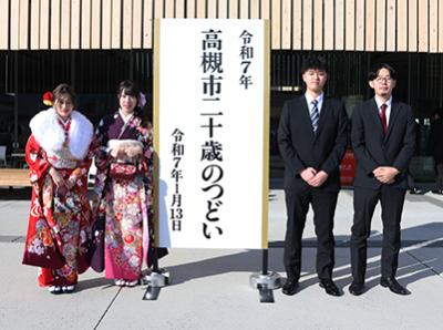 看板と記念撮影する新成人
