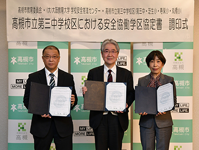 協定書を持つ西田教育長、藤田センター長、岡田校長