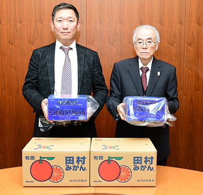 寄贈品を持つ梅原社長と石下副市長
