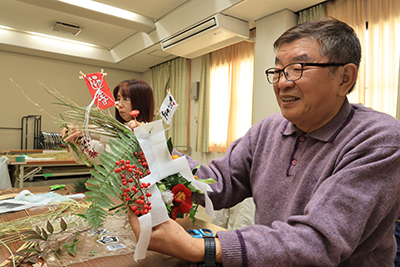 しめ縄に飾り付けをする参加者