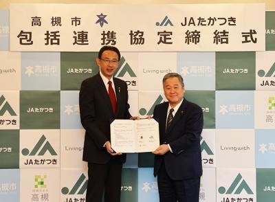 協定書を持つ森本会長と濱田市長